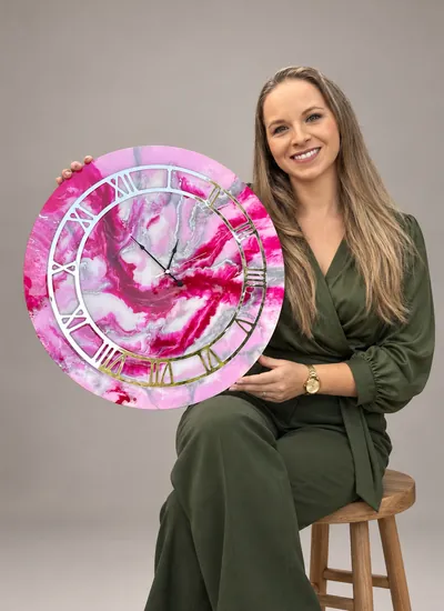 Ana com relógio de resina rosa com aro de números romanos espelhados
